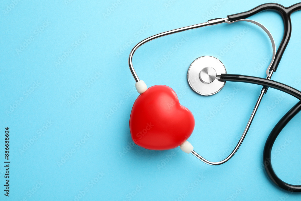 Stethoscope and red heart on light blue background, top view. Space for text Stethoscope and red heart on light blue background, top view. Space for text