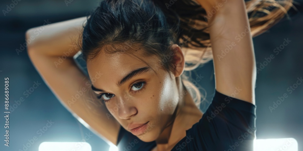 Fototapeta premium A woman holds a tennis racquet, ready to play