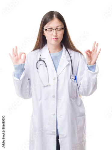 Young Chinese doctor woman over isolated background relax and smiling with eyes closed doing meditation gesture with fingers. Yoga concept.