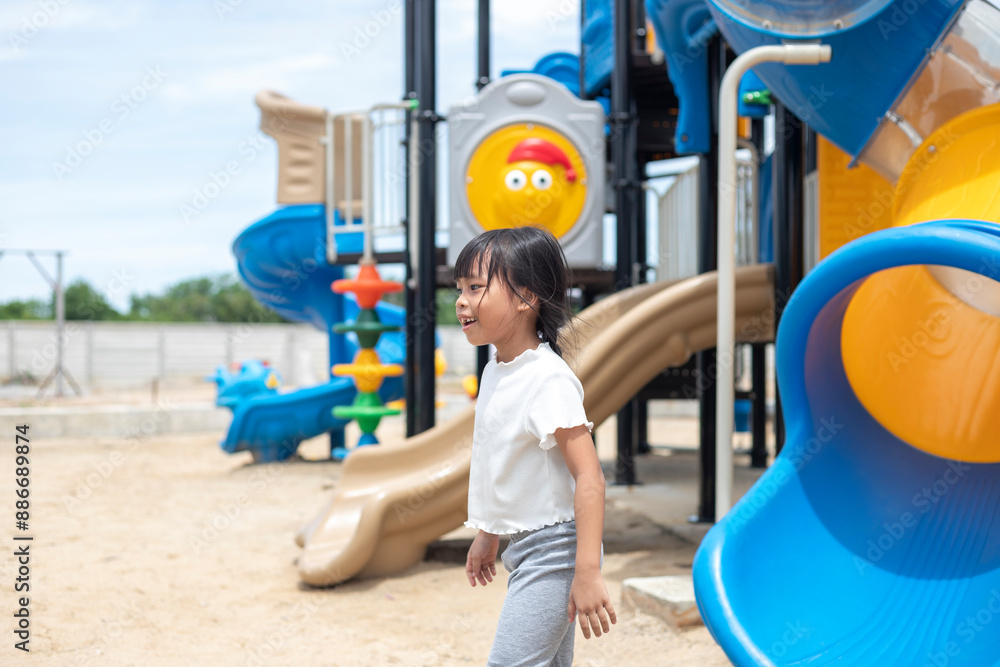 A young girl is sitting on a sky blue slide, smiling and waving. Concept of joy and excitement, as the girl is enjoying her time at the playground A young girl is sitting on a sky blue slide, smiling and waving. Concept of joy and excitement, as the girl is enjoying her time at the playground