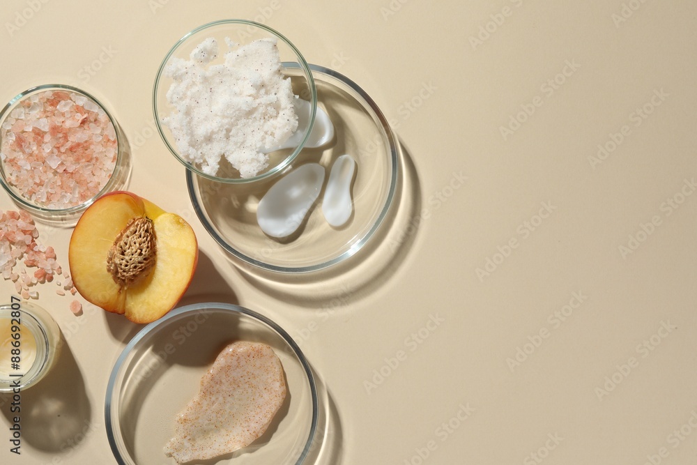Petri dishes with different cosmetic products and peach on beige background, flat lay. Space for text Petri dishes with different cosmetic products and peach on beige background, flat lay. Space for text