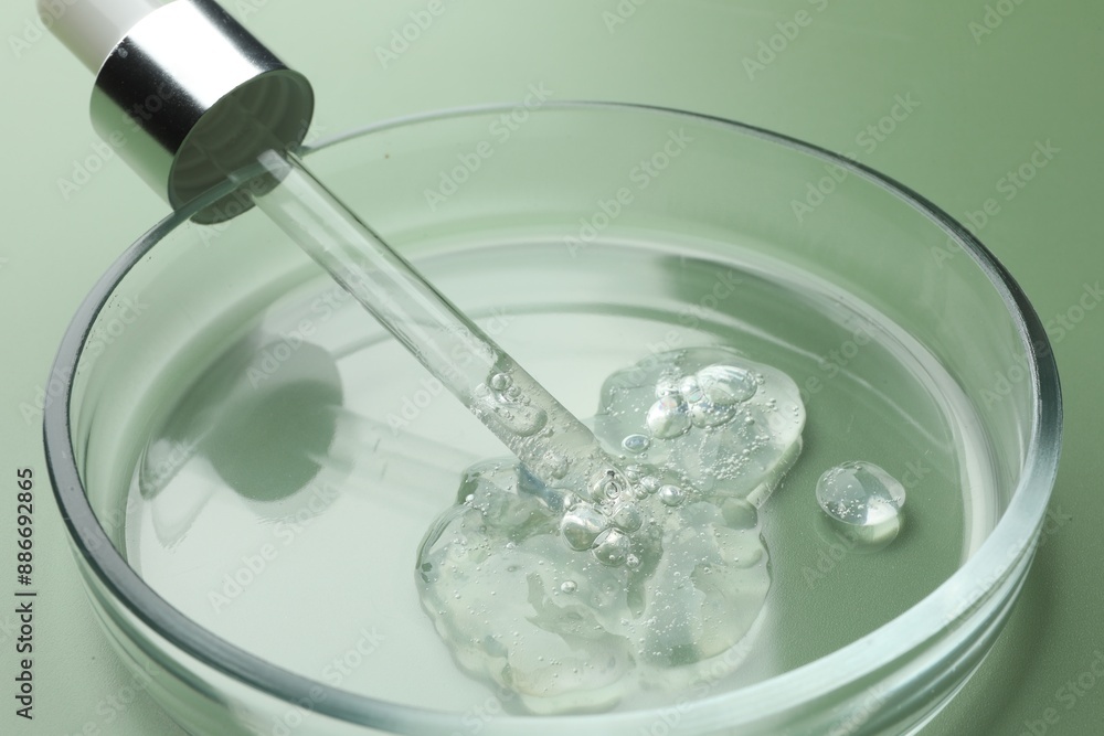 Petri dish with cosmetic product and pipette on green background, closeup Petri dish with cosmetic product and pipette on green background, closeup