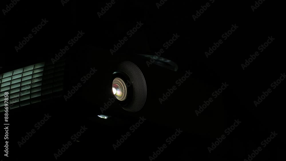 Particles In Cinema Projector Light. Closeup of a lens projecting light with colorful dust floating around it Particles In Cinema Projector Light. Closeup of a lens projecting light with colorful dust floating around it
