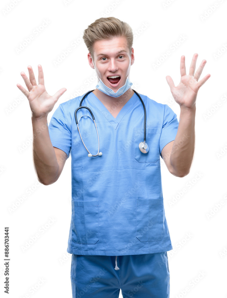 Young handsome blond doctor very happy and excited, winner expression celebrating victory screaming with big smile and raised hands Young handsome blond doctor very happy and excited, winner expression celebrating victory screaming with big smile and raised hands