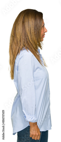 Beautiful middle age business adult woman over isolated background looking to side, relax profile pose with natural face with confident smile.