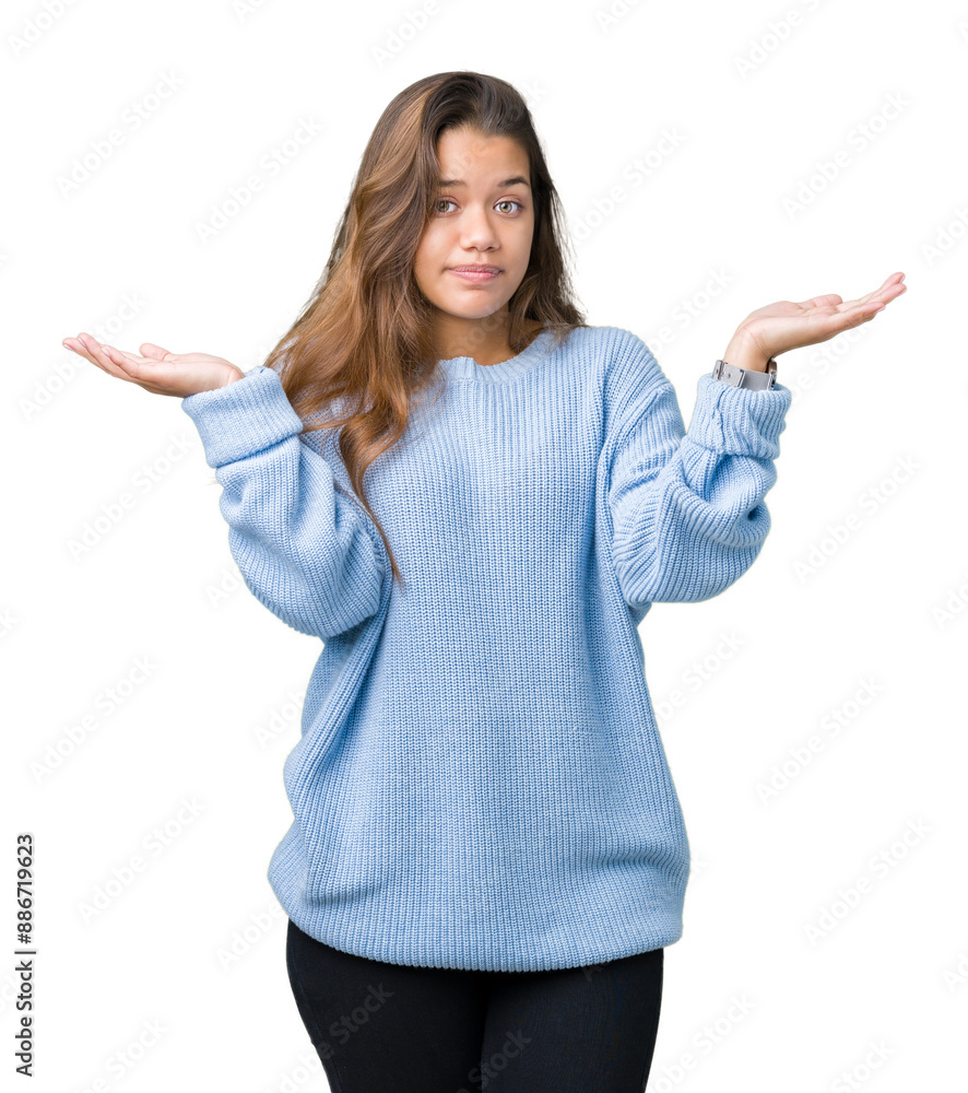 Young beautiful brunette woman wearing blue winter sweater over isolated background clueless and confused expression with arms and hands raised. Doubt concept. Young beautiful brunette woman wearing blue winter sweater over isolated background clueless and confused expression with arms and hands raised. Doubt concept.