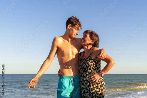 Photos Hispanic woman in her 70s on the beach with her grandson, about 17 years old