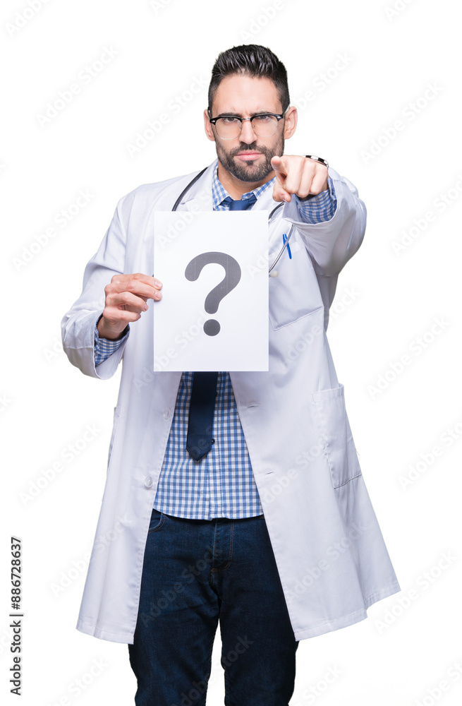 Obraz na plátně Handsome young doctor man holding paper with question mark over isolated backgro