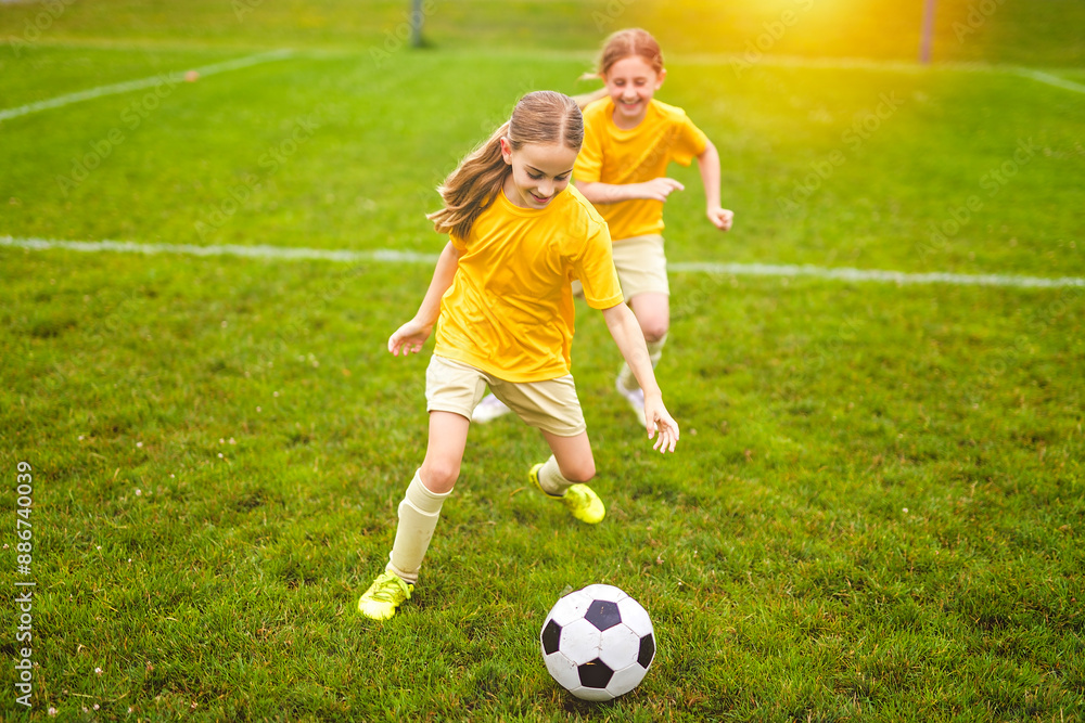 Kids play football on outdoor field at the end of the day Kids play football on outdoor field at the end of the day