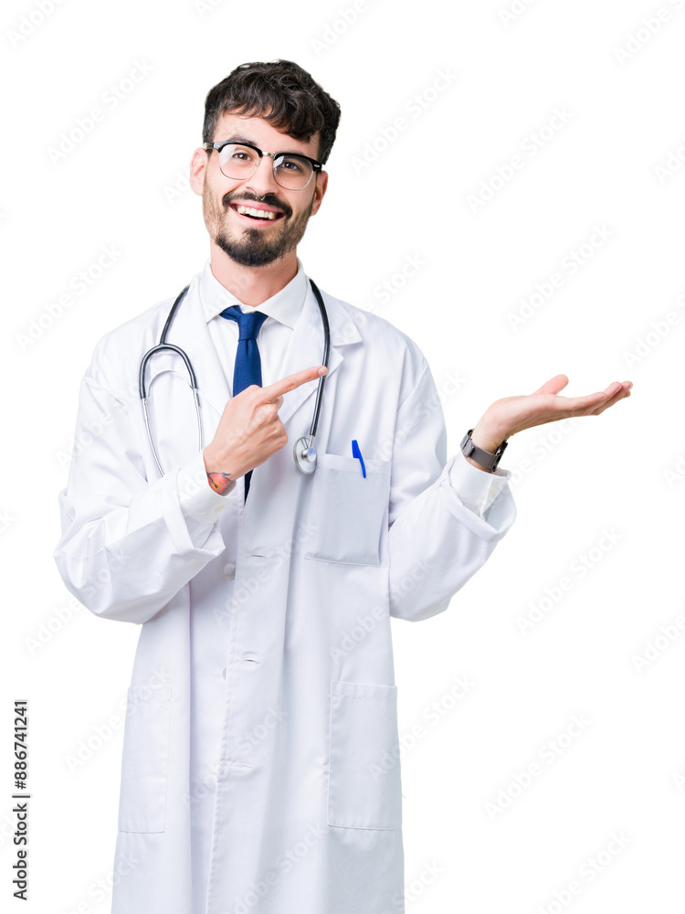 Young doctor man wearing hospital coat over isolated background amazed and smiling to the camera while presenting with hand and pointing with finger. Young doctor man wearing hospital coat over isolated background amazed and smiling to the camera while presenting with hand and pointing with finger.