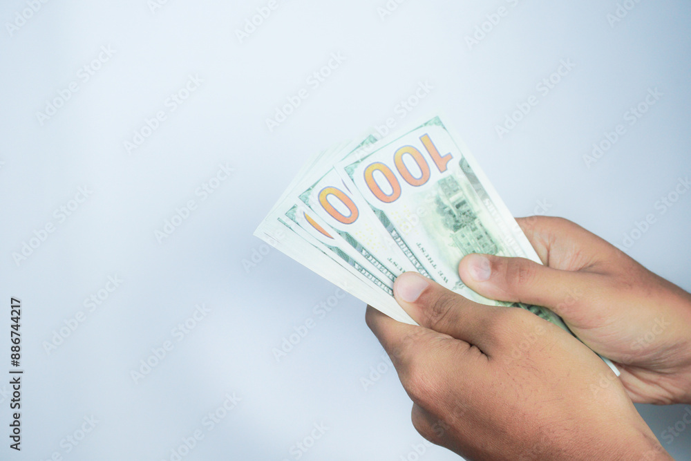 finance, currency and people concept - close up of hand holding 100 dollar banknotes over white background finance, currency and people concept - close up of hand holding 100 dollar banknotes over white background