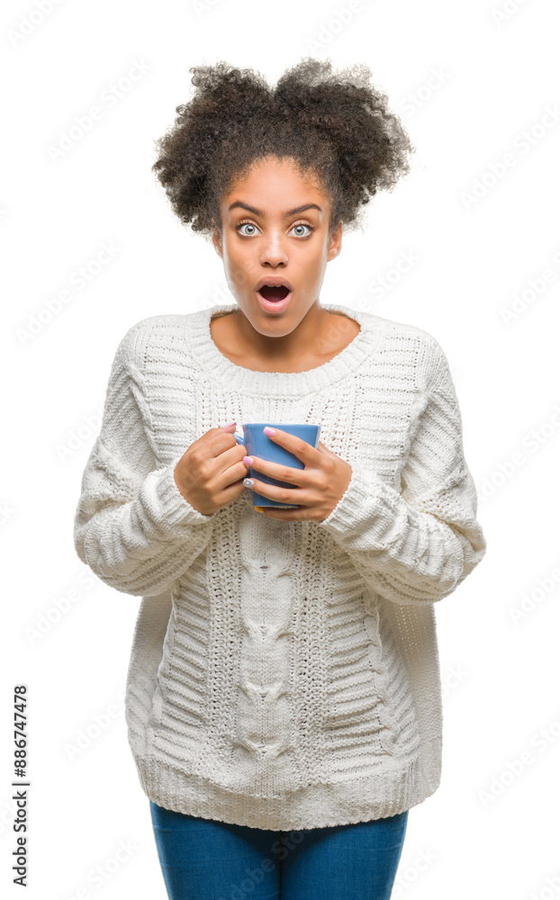 Young afro american woman driking cup of coffee over isolated background scared in shock with a surprise face, afraid and excited with fear expression Young afro american woman driking cup of coffee over isolated background scared in shock with a surprise face, afraid and excited with fear expression