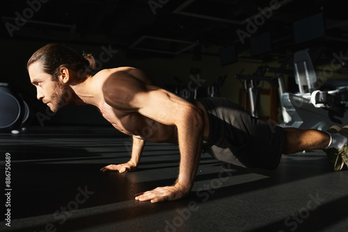 Muscular shirtless man doing push ups in a gym.