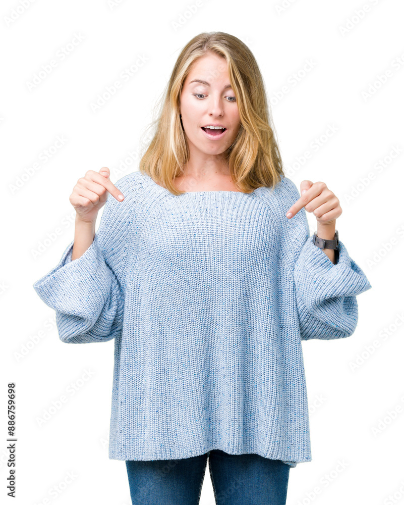 Beautiful young woman wearing blue sweater over isolated background Pointing down with fingers showing advertisement, surprised face and open mouth Beautiful young woman wearing blue sweater over isolated background Pointing down with fingers showing advertisement, surprised face and open mouth