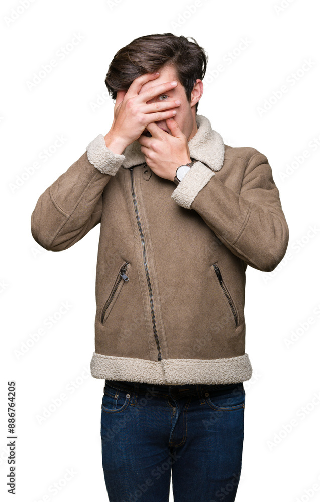 Young handsome man wearing winter coat over isolated background Covering eyes and mouth with hands, surprised and shocked. Hiding emotion Young handsome man wearing winter coat over isolated background Covering eyes and mouth with hands, surprised and shocked. Hiding emotion