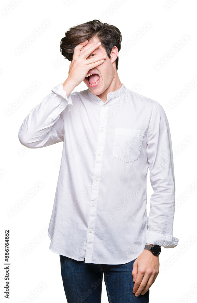 Young handsome business man over isolated background peeking in shock covering face and eyes with hand, looking through fingers with embarrassed expression. Young handsome business man over isolated background peeking in shock covering face and eyes with hand, looking through fingers with embarrassed expression.