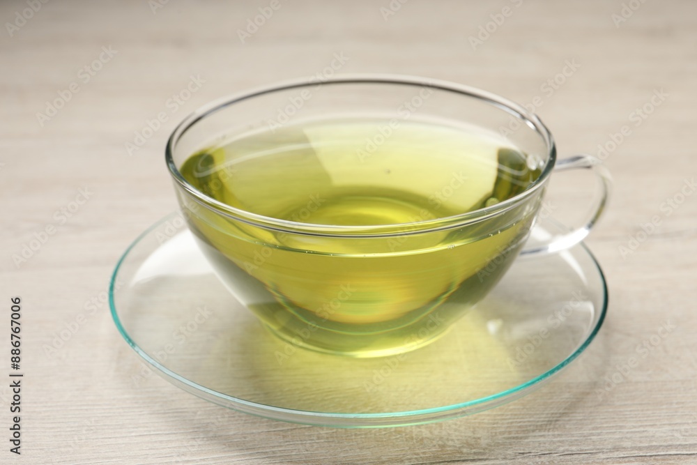 Refreshing green tea in cup on wooden table, closeup Refreshing green tea in cup on wooden table, closeup