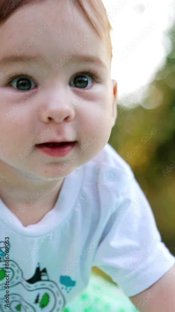 Adorable healthy Caucasian child resting on the plaid in the garden. Lovely boy looking at the apple in his hands. Blurred nature backdrop. Vertical video Adorable healthy Caucasian child resting on the plaid in the garden. Lovely boy looking at the apple in his hands. Blurred nature backdrop. Vertical video