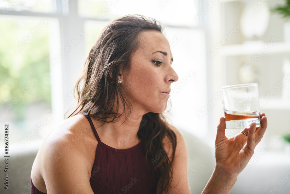alone depressed woman drink booze on sofa at home. Treatment of alcohol addiction, suffer abuse problem alcoholism. alone depressed woman drink booze on sofa at home. Treatment of alcohol addiction, suffer abuse problem alcoholism.