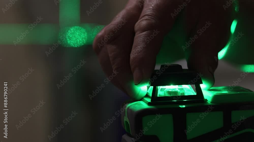 Builder is measures the repair lines for laying tiles using a laser level with green beams. Close up, 4k footage. Builder is measures the repair lines for laying tiles using a laser level with green beams. Close up, 4k footage.