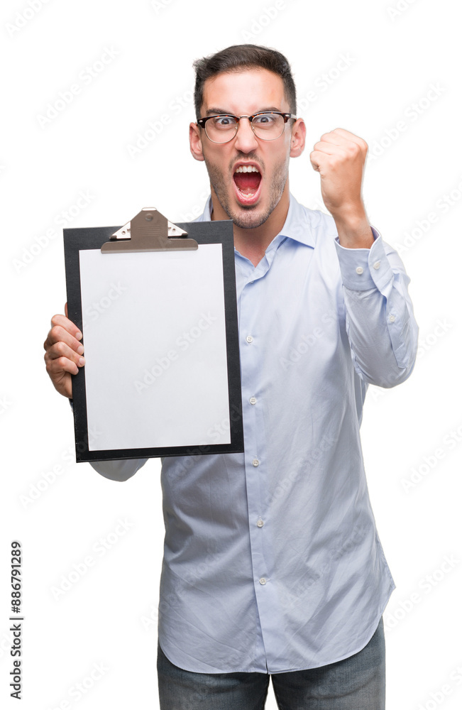 Handsome young business man showing a clipboard annoyed and frustrated shouting with anger, crazy and yelling with raised hand, anger concept Handsome young business man showing a clipboard annoyed and frustrated shouting with anger, crazy and yelling with raised hand, anger concept