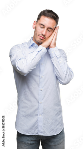 Handsome young businessman sleeping tired dreaming and posing with hands together while smiling with closed eyes.