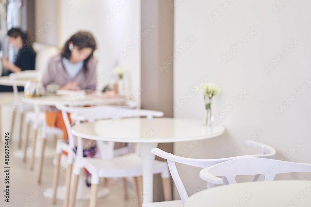 Abstract blurred coffee shop with a woman at a table in a supermarket on a light blurred background cafe with space to copy. High quality photo Abstract blurred coffee shop with a woman at a table in a supermarket on a light blurred background cafe with space to copy. High quality photo