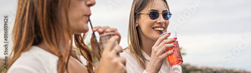 Young women enjoying refreshing drinks outdoors, friendship and summer lifestyle concept