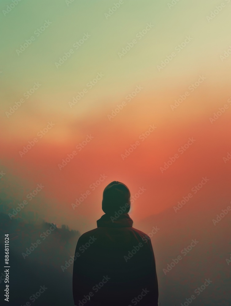 Lonely man sitting on mountaintop in sunset Lonely man sitting on mountaintop in sunset