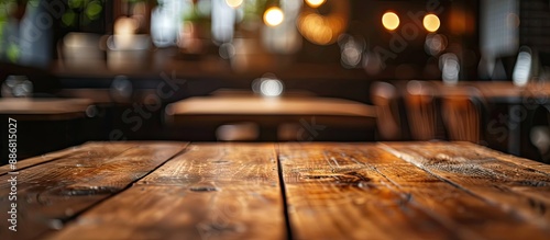 Focused on an empty brown wooden table in a coffee shop background with bokeh, ideal for showcasing products in a montage with copy space image.