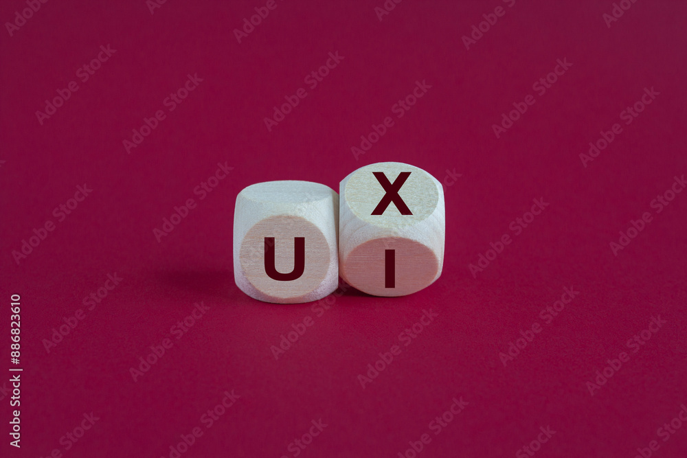 UX design or UI design. Turned cube and changed the words 'UX' to 'UI'. Beautiful red background. Business concept. Copy space. UX design or UI design. Turned cube and changed the words 'UX' to 'UI'. Beautiful red background. Business concept. Copy space.