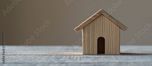 A small wooden house on a neutral gray backdrop with copy space image. Investment in real estate for renting to young families with affordable loans for property construction. photo