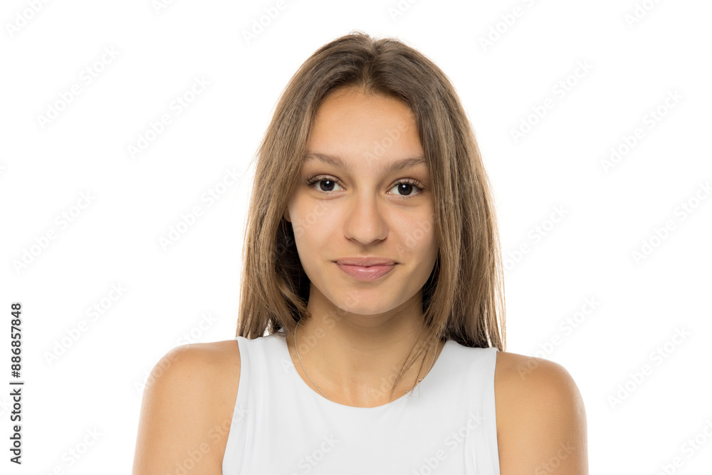 Portrait of beautiful young smiling brunette woman without makeup on white studio wall. Pretty female with straight hair in white shirt Portrait of beautiful young smiling brunette woman without makeup on white studio wall. Pretty female with straight hair in white shirt