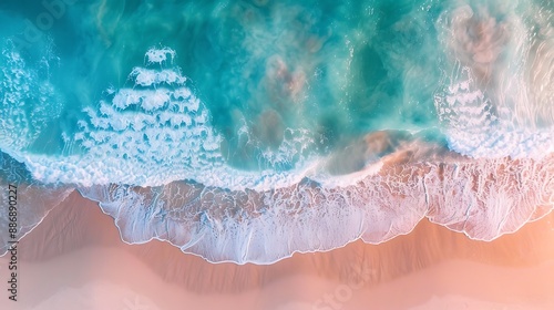 High-definition aerial view of waves in patterns of turquoise and azure, bordered by a sandy shoreline and a horizon of hazy lilac and peach.