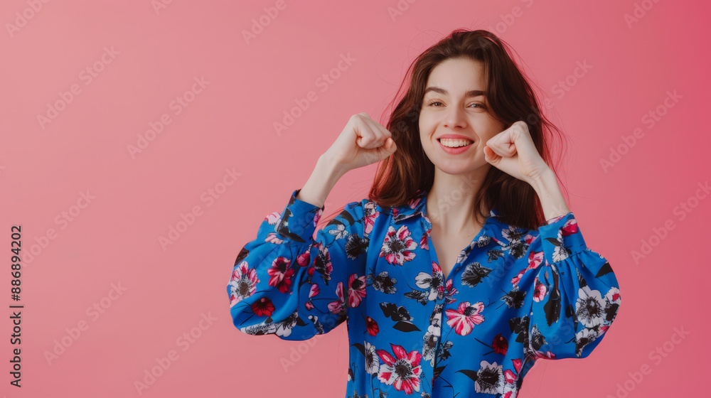 portrait of a woman raising hands in front of pink background