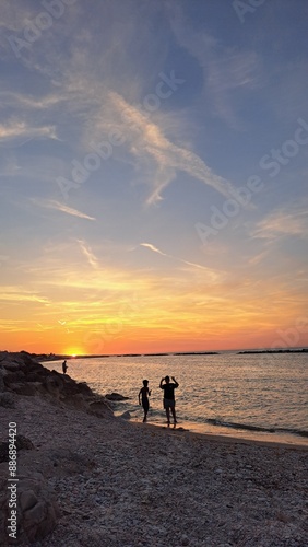 ragazzi in riva la mare al tramonto