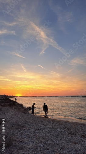 ragazzi in riva la mare al tramonto