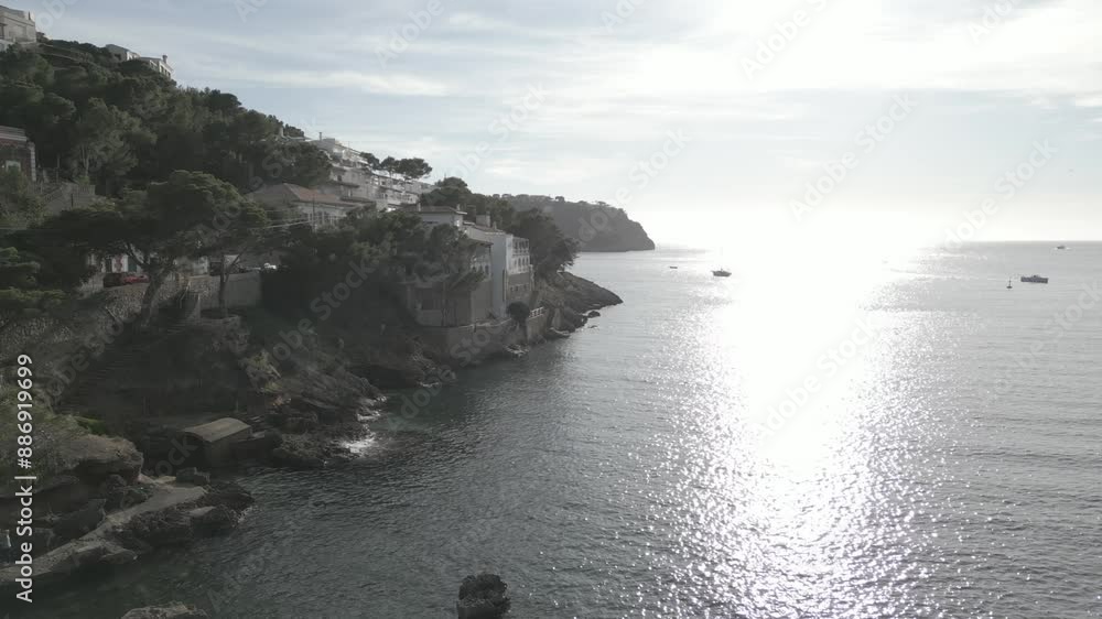 Aerial view of villas, rocky shoreline and sun reflecting on the sea, Port d'Andratx, Majorca, Balearic Islands, Spain, Mediterranean, Europe Aerial view of villas, rocky shoreline and sun reflecting on the sea, Port d'Andratx, Majorca, Balearic Islands, Spain, Mediterranean, Europe