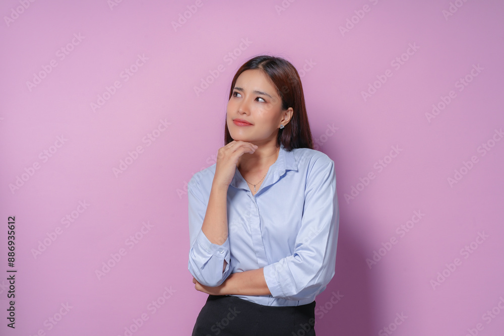 Young businesswoman wearing a blue shirt and black skirt is deep in thought, her hand resting on her chin as she contemplates a decision Young businesswoman wearing a blue shirt and black skirt is deep in thought, her hand resting on her chin as she contemplates a decision