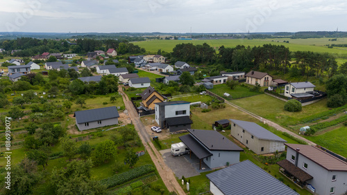 Drone photography of small town surrounded by forest during summer day