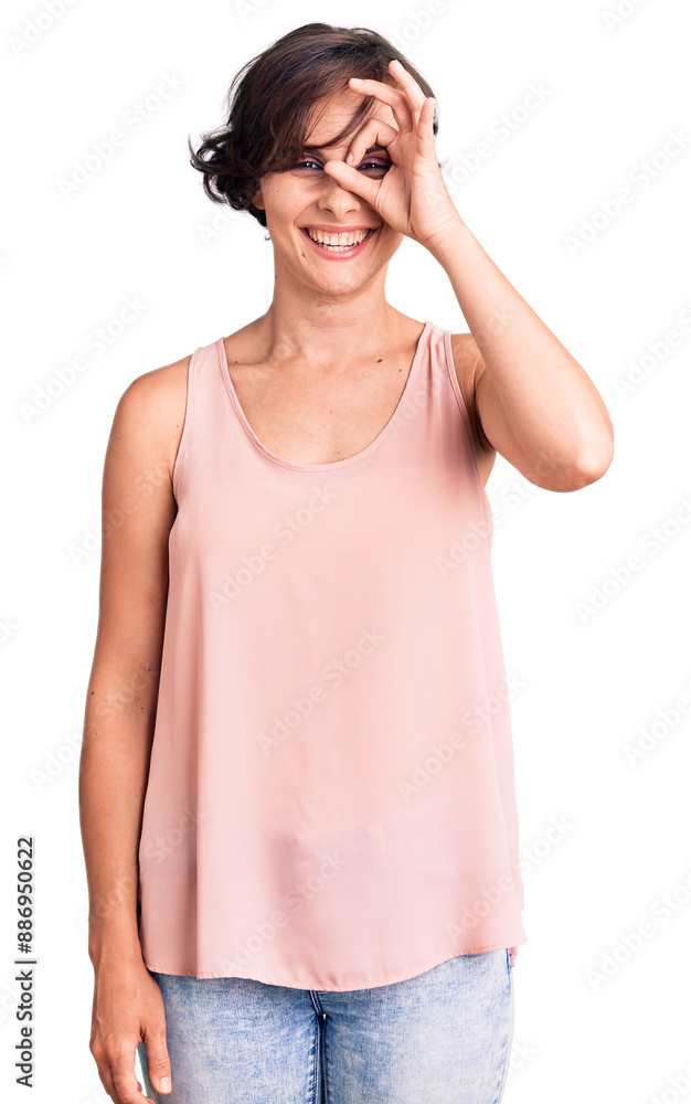 Beautiful young woman with short hair wearing casual style with sleeveless shirt doing ok gesture with hand smiling, eye looking through fingers with happy face. Beautiful young woman with short hair wearing casual style with sleeveless shirt doing ok gesture with hand smiling, eye looking through fingers with happy face.