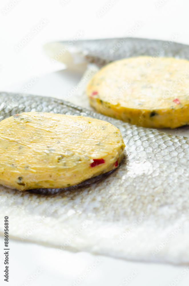 A piece of fish with a herbs butter on top of it A piece of fish with a herbs butter on top of it