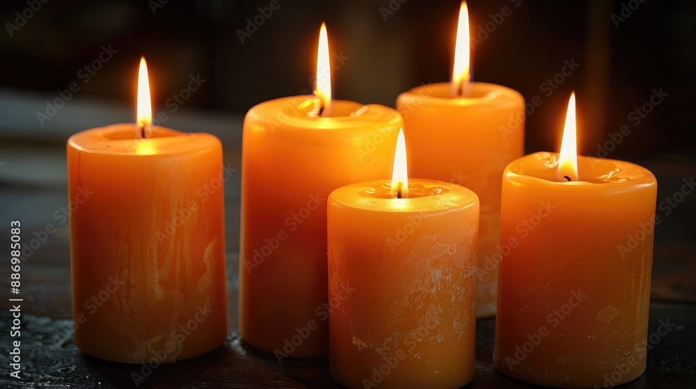 Closeup of five candles burning on table with dark background Closeup of five candles burning on table with dark background
