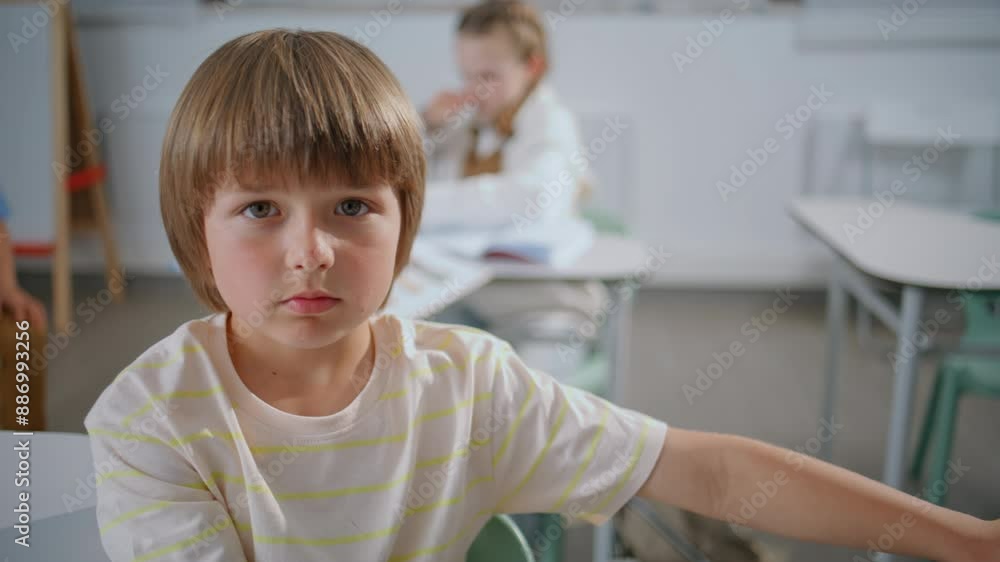 Closeup smart pupil studying at elementary school. Boy looking camera portrait Closeup smart pupil studying at elementary school. Boy looking camera portrait