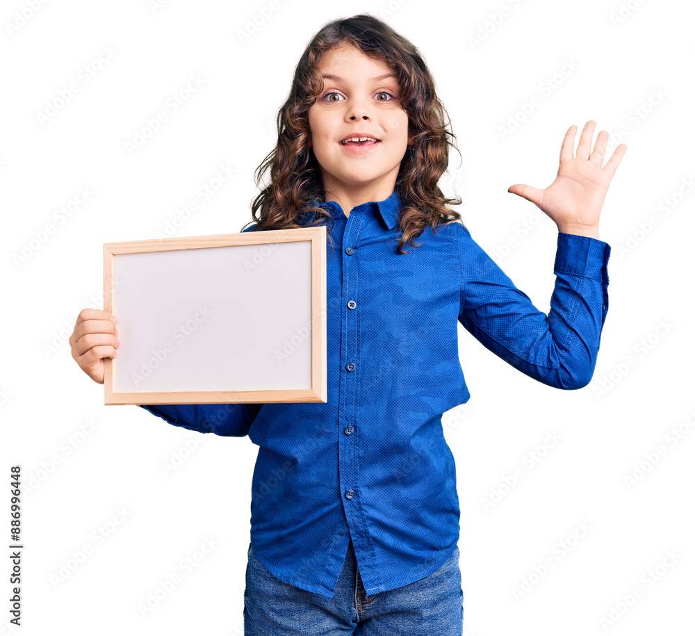Cute hispanic child with long hair holding empty white chalkboard celebrating victory with happy smile and winner expression with raised hands Cute hispanic child with long hair holding empty white chalkboard celebrating victory with happy smile and winner expression with raised hands