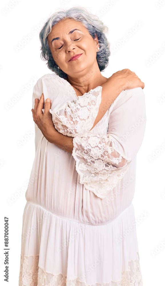 Senior woman with gray hair wearing bohemian style hugging oneself happy and positive, smiling confident. self love and self care Senior woman with gray hair wearing bohemian style hugging oneself happy and positive, smiling confident. self love and self care