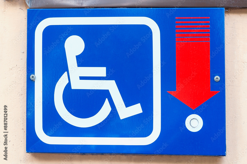 Metal tablet with signal button for the disabled people on the building wall Metal tablet with signal button for the disabled people on the building wall