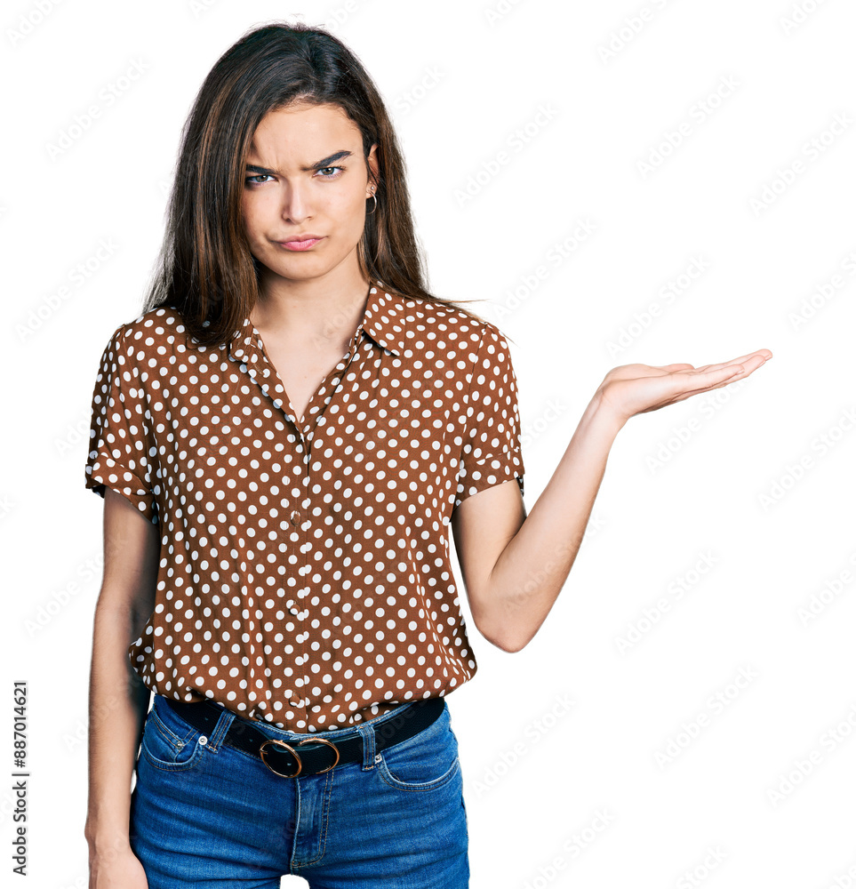 Young caucasian girl presenting with open palms, holding something skeptic and nervous, frowning upset because of problem. negative person. Young caucasian girl presenting with open palms, holding something skeptic and nervous, frowning upset because of problem. negative person.
