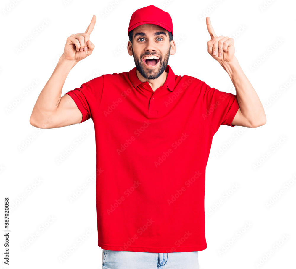Young handsome man with beard wearing delivery uniform smiling amazed and surprised and pointing up with fingers and raised arms. Young handsome man with beard wearing delivery uniform smiling amazed and surprised and pointing up with fingers and raised arms.