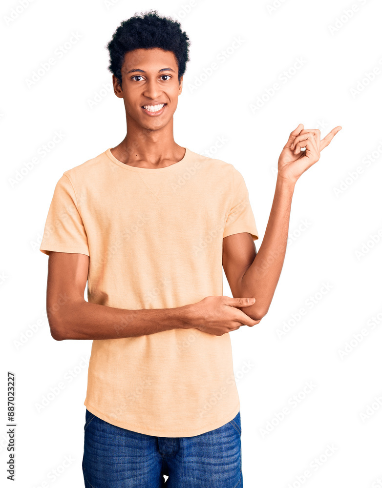 Young african american man wearing casual clothes with a big smile on face, pointing with hand and finger to the side looking at the camera. Young african american man wearing casual clothes with a big smile on face, pointing with hand and finger to the side looking at the camera.